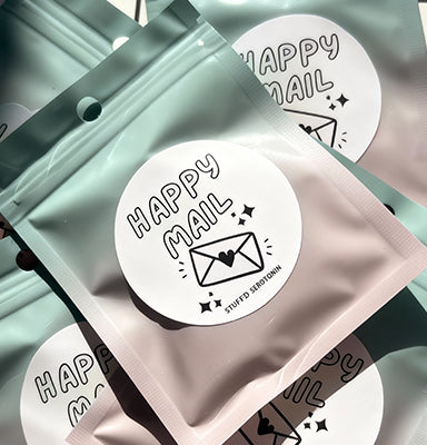 Packaging with 'Happy Mail' labels on a light green background